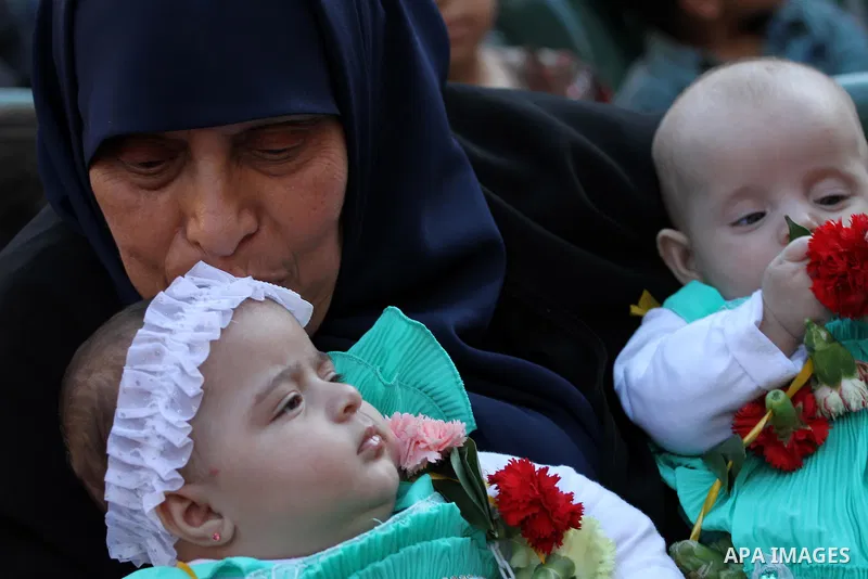 A woman carries her prisoner son twins, who were born from her son's smuggled sperm from Israeli jails, during a protest demanding visit her son, outside the Red Cross office, in Gaza city on May 7, 2015. Some 24 wives o...