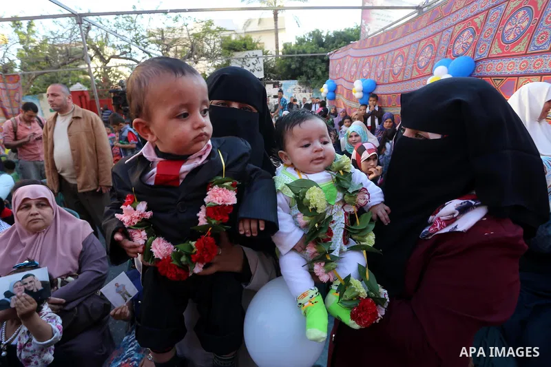 Wifes of Palestinian prisoners in Israeli jails, carry their babies, who were born from their husbands' smuggled sperms, during a protest demanding visit their husbands, outside the Red Cross office, in Gaza city on May...