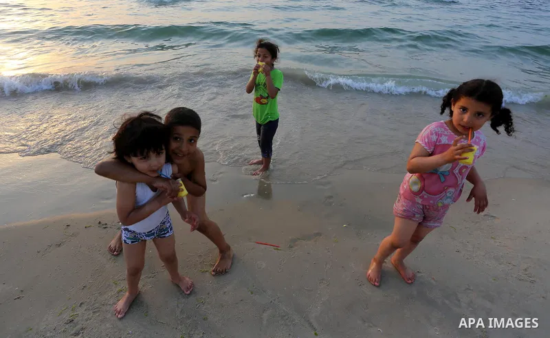 Palestinian children enjoy their time during sunset at the beach of Gaza sea on May 9, 2015. Photo by Mohammed Asad
