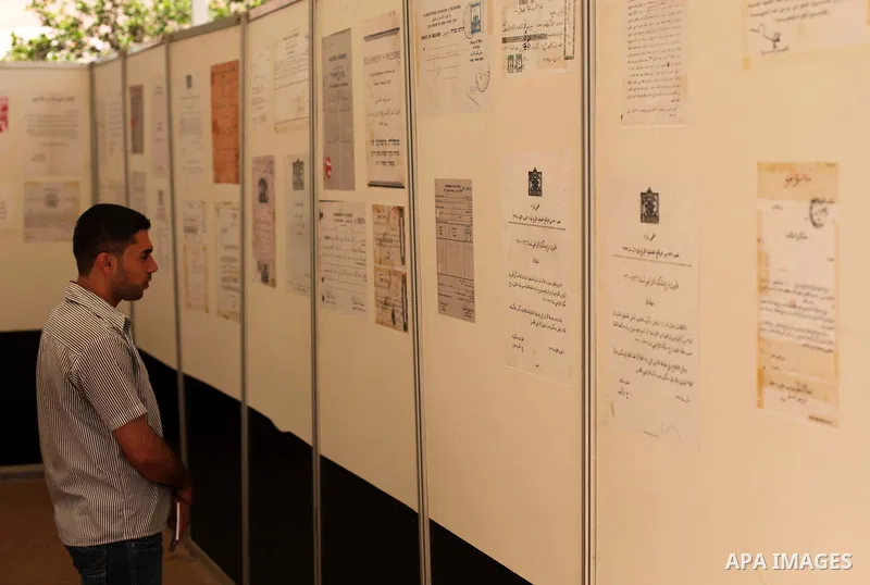 A Palestinian man reads an old document that written before the Nakba, during a historical documents gallery in Gaza city on May 14, 2015. ''Nakba'' means in Arabic ''catastrophe'' in reference to the birth of the state...