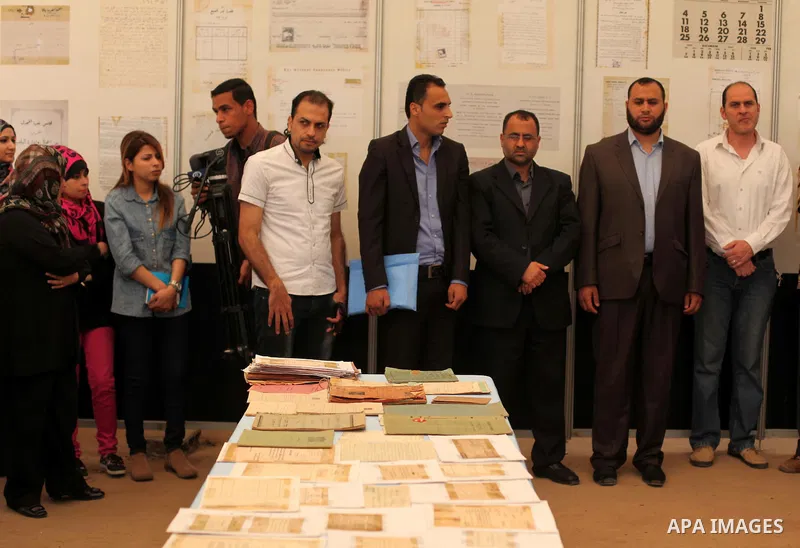 Palestinians read old documents that written before the Nakba, during a historical documents gallery in Gaza city on May 14, 2015. ''Nakba'' means in Arabic ''catastrophe'' in reference to the birth of the state of Israe...