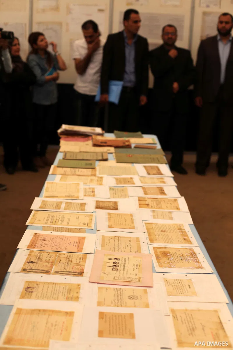 Palestinians read old documents that written before the Nakba, during a historical documents gallery in Gaza city on May 14, 2015. ''Nakba'' means in Arabic ''catastrophe'' in reference to the birth of the state of Israe...