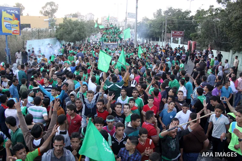 Palestinian members of al-Shijaiyah football club with their fans, celebrate winning Gaza league championship, near the rubbles of houses which where destroyed during the recent Israeli war in the summer of 2014, at al-S...