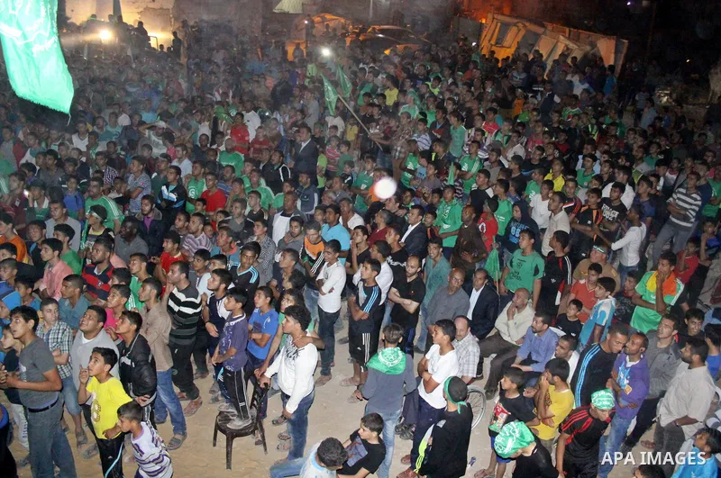Palestinian members of al-Shijaiyah football club with their fans, celebrate winning Gaza league championship, near the rubbles of houses which where destroyed during the recent Israeli war in the summer of 2014, at al-S...