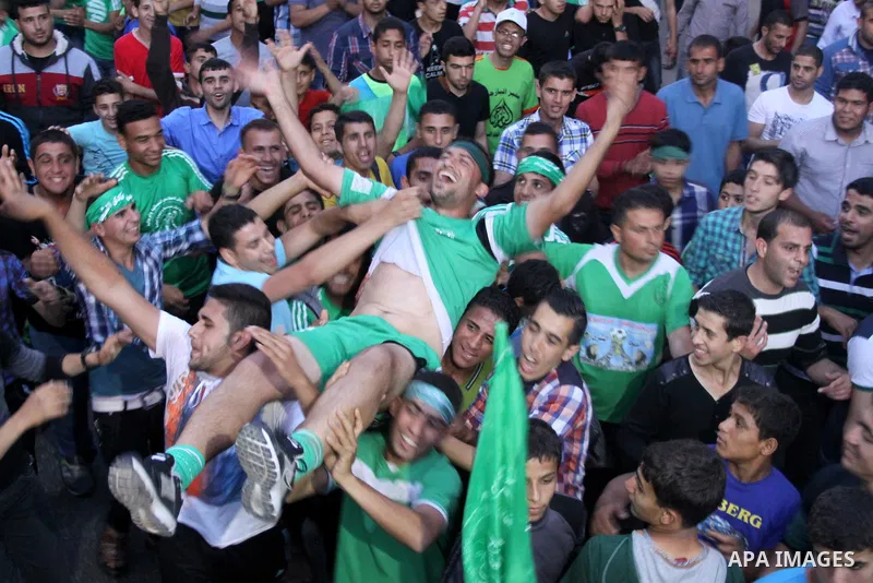 Palestinian members of al-Shijaiyah football club with their fans, celebrate winning Gaza league championship, near the rubbles of houses which where destroyed during the recent Israeli war in the summer of 2014, at al-S...