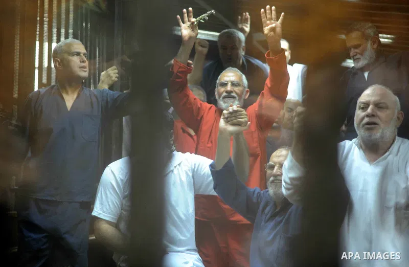 Muslim Brotherhood's Supreme Guide Mohamed Badie (C) reacts with other brotherhood members at a court in the outskirts of Cairo, Egypt May 16, 2015. An Egyptian court on Saturday sought the death penalty for former presi...
