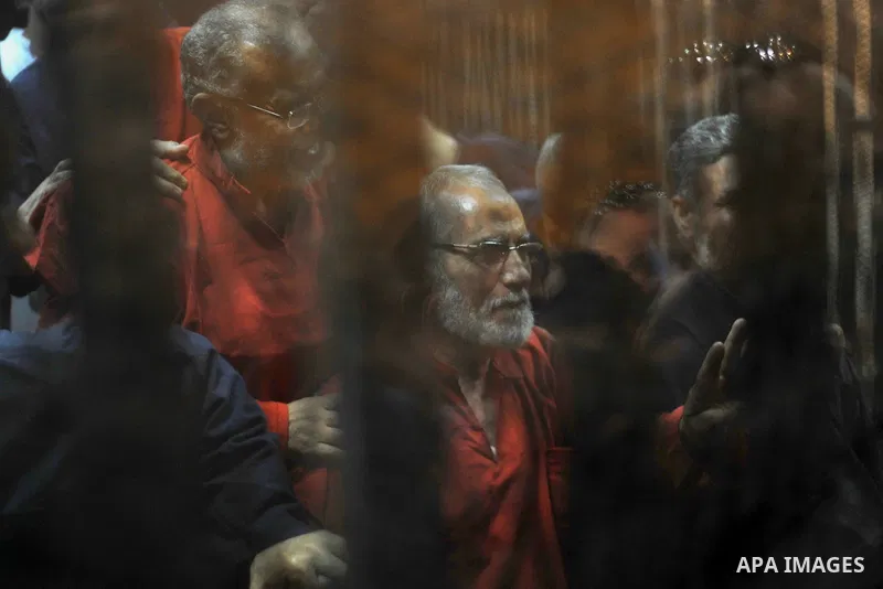 Muslim Brotherhood's Supreme Guide Mohamed Badie (C) reacts with other brotherhood members at a court in the outskirts of Cairo, Egypt May 16, 2015. An Egyptian court on Saturday sought the death penalty for former presi...