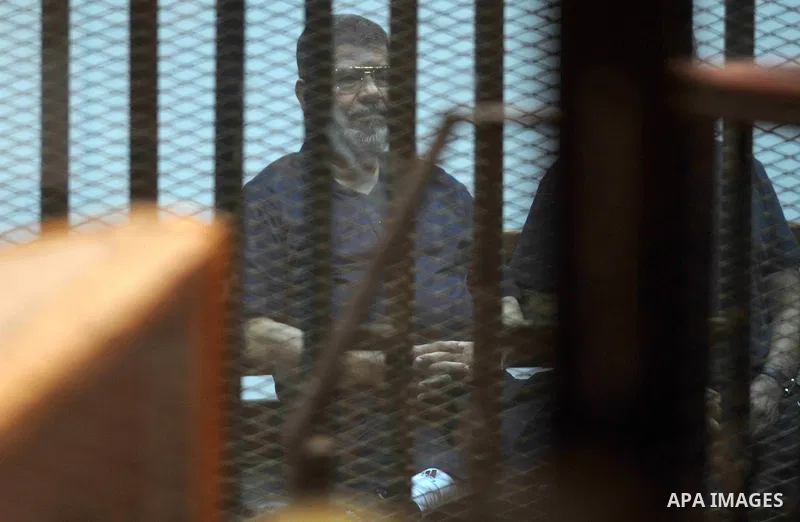 Former Egyptian President Mohamed Mursi waves as he enters for his trial with other Muslim Brotherhood members at a court in the outskirts of Cairo, May 16, 2015. An Egyptian court on Saturday sought the death penalty fo...