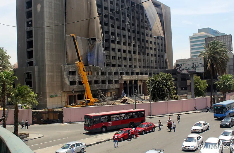 Egyptian workers use a crane to pull down National Democratic Party building, in Cairo on May 17, 2015. Last month, the Egyptian cabinet made a decision to pull down the headquarters of the currently-dismantled National...