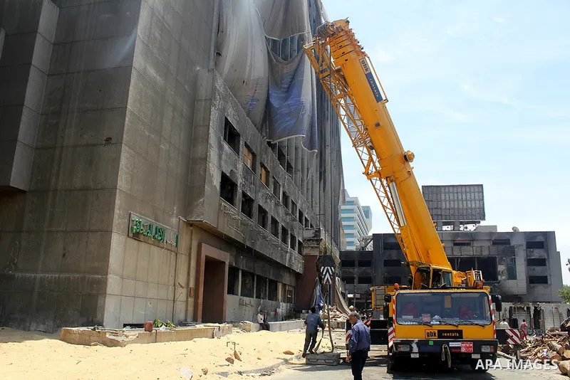 Egyptian workers use a crane to pull down National Democratic Party building, in Cairo on May 17, 2015. Last month, the Egyptian cabinet made a decision to pull down the headquarters of the currently-dismantled National...