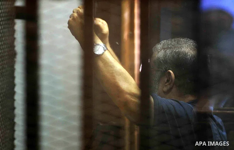 Egypt's deposed Islamist president Mohamed Morsi, is seen behind bars during his trial in a case of the "communicating with Qatar" at the court, in Cairo, on May 19, 2015. Photo by Stringer