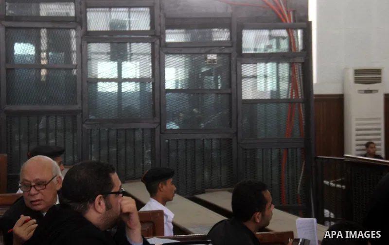 Suspects of Ansar Bait Al-Maqdis group, stand behind bars in a court room, during their trial in Cairo on May 19, 2015. Photo by Stringer