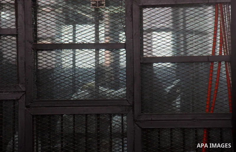 Suspects of Ansar Bait Al-Maqdis group, stand behind bars in a court room, during their trial in Cairo on May 19, 2015. Photo by Stringer