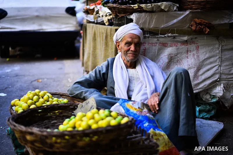 An Egyptian man sells fruits at a street market in Ad Duqqi district, near Cairo on May 19, 2015. Egypt suspended a capital gains tax on Monday, sending shares soaring after a months-long downturn in which investors had...