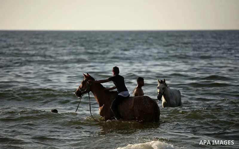 Palestinians enjoy a day on a warm day in the Mediterranean Sea beach, off the coast of Gaza City on May 20, 2015. Photo by Ashraf Amra