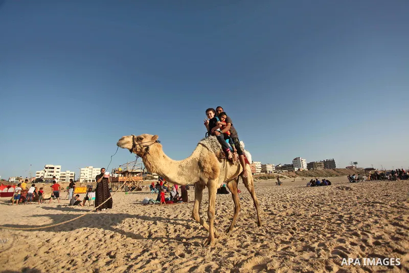 Palestinians enjoy a day on a warm day in the Mediterranean Sea beach, off the coast of Gaza City on May 20, 2015. Photo by Ashraf Amra