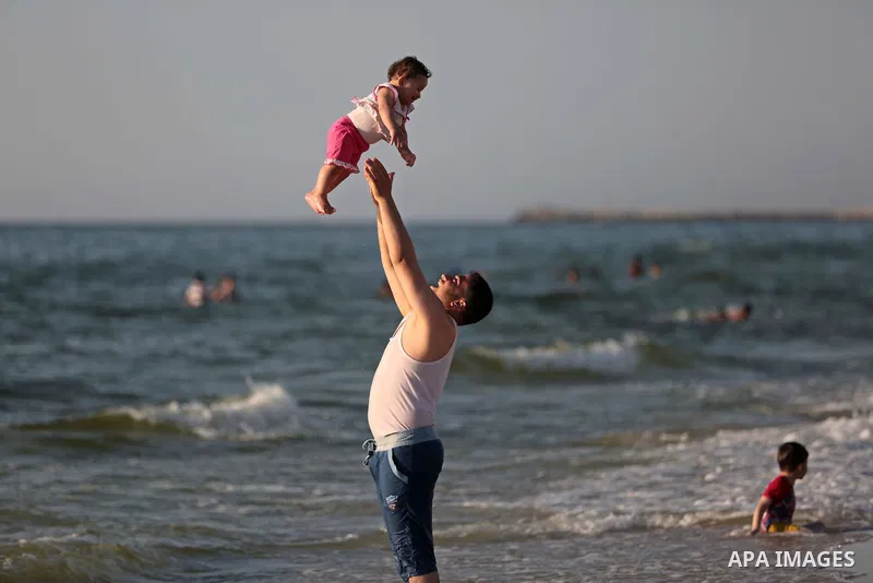 Palestinians enjoy a day on a warm day in the Mediterranean Sea beach, off the coast of Gaza City on May 20, 2015. Photo by Ashraf Amra