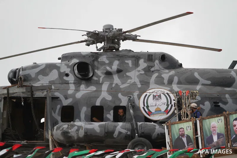 The broken helicopter of late Palestinian President Yasser Arafat is placed on top of a structure as members of Palestinian security forces march during a military graduation ceremony in Gaza City May 21, 2015. Photo by...
