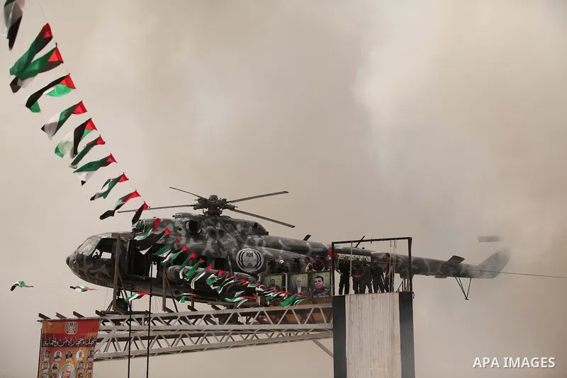 The broken helicopter of late Palestinian President Yasser Arafat is placed on top of a structure as members of Palestinian security forces march during a military graduation ceremony in Gaza City May 21, 2015. Photo by...