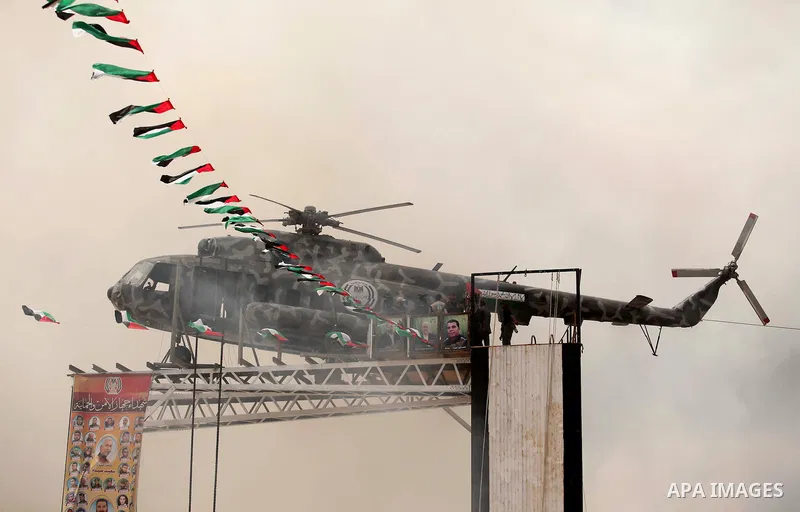 The broken helicopter of late Palestinian President Yasser Arafat is placed on top of a structure as members of Palestinian security forces march during a military graduation ceremony in Gaza City May 21, 2015. Photo by...