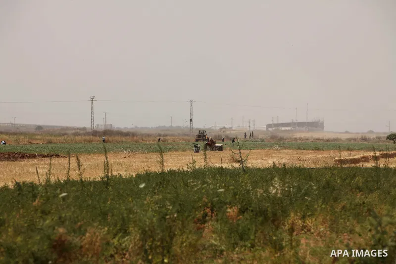 Palestinian workers use a bulldozer to build a street near the border with Israel, in Gaza City, on May 23, 2015. Photo by Ashraf Amra