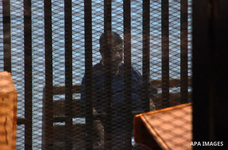 Ousted Egyptian president Mohamed Morsi, who was recently sentenced to death, gestures during his new trial in Cairo on May 23, 2015, with 25 other defendants including prominent Islamists and secular figures on trial fo...