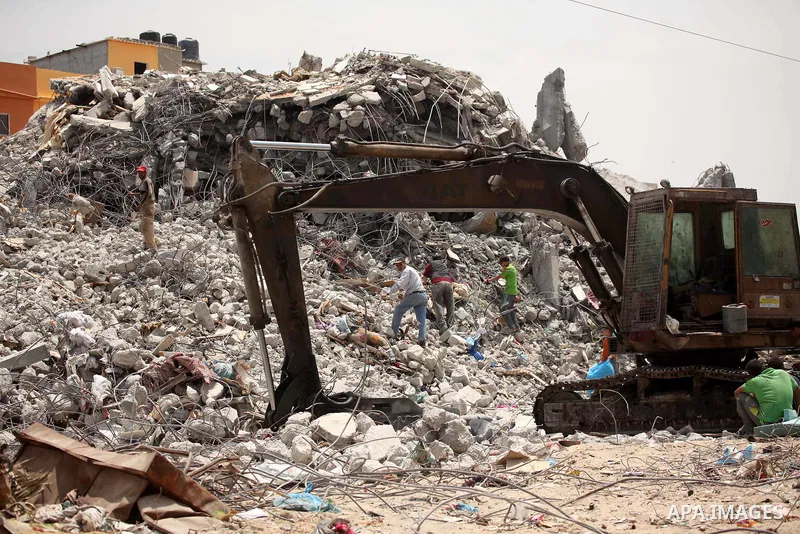 Palestinian men work amid the rubble of houses which were destroyed during the 50-day war between Israel and Hamas militants in the summer of 2014, in the Eastern Gaza City Shujaiya neighbourhood, on May 23, 2015. Photo...