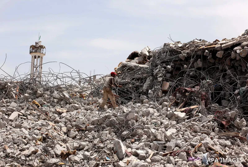 Palestinian men work amid the rubble of houses which were destroyed during the 50-day war between Israel and Hamas militants in the summer of 2014, in the Eastern Gaza City Shujaiya neighbourhood, on May 23, 2015. Photo...