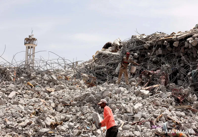 Palestinian men work amid the rubble of houses which were destroyed during the 50-day war between Israel and Hamas militants in the summer of 2014, in the Eastern Gaza City Shujaiya neighbourhood, on May 23, 2015. Photo...