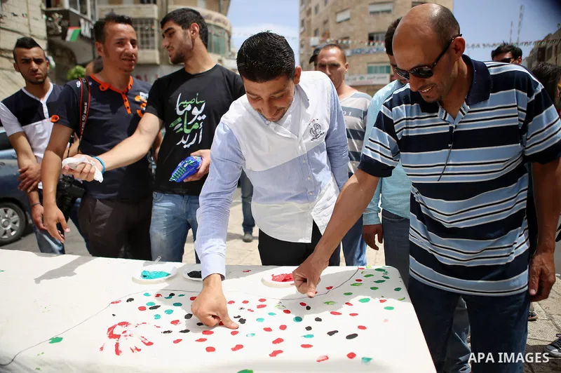 Palestinians lay hands imprint as they take part in a rally marking the 67th anniversary of the "Nakba, in the West Bank city of Ramallah, on May 26, 2015. Photo by Shadi Hatem