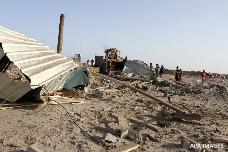 Palestinian men look at a crater on the ground following an Israeli airstrike in the southern Gaza Strip near the town, of Rafah on May 27,2015. The Israeli air force carried out four strikes on militant targets in the G...