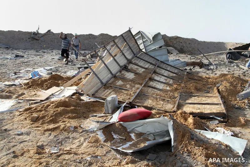 Palestinian men look at a crater on the ground following an Israeli airstrike in the southern Gaza Strip near the town, of Rafah on May 27,2015. The Israeli air force carried out four strikes on militant targets in the G...