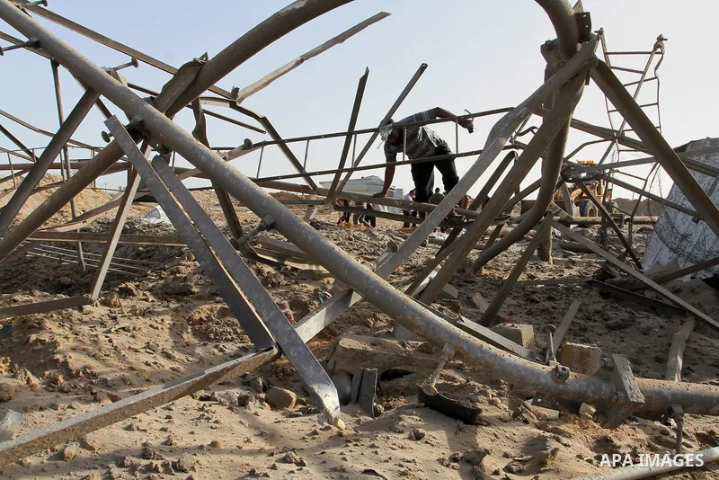 A Palestinian man looks at a crater on the ground following an Israeli airstrike in the southern Gaza Strip near the town, of Rafah on May 27,2015. The Israeli air force carried out four strikes on militant targets in th...