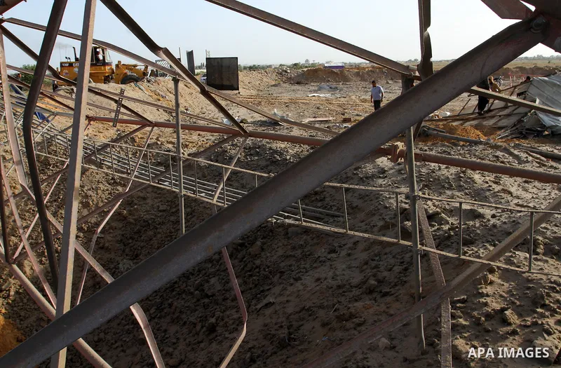 Palestinian men look at a crater on the ground following an Israeli airstrike in the southern Gaza Strip near the town, of Rafah on May 27,2015. The Israeli air force carried out four strikes on militant targets in the G...