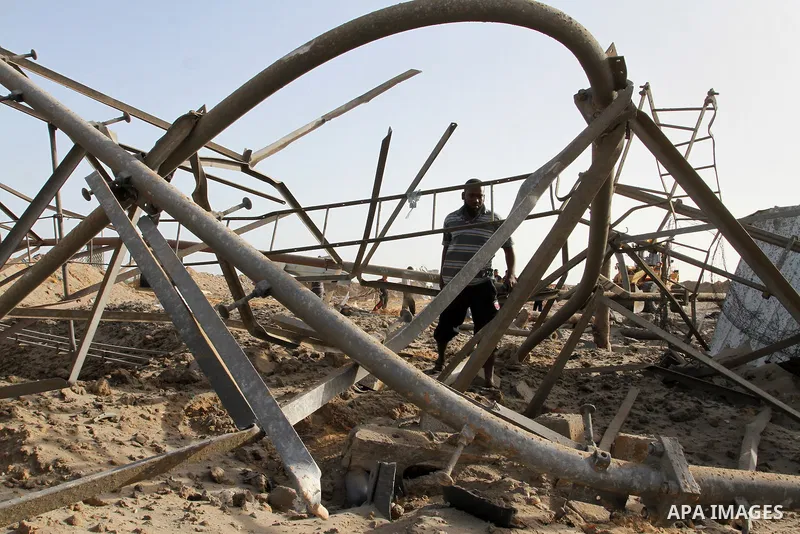 A Palestinian man looks at a crater on the ground following an Israeli airstrike in the southern Gaza Strip near the town, of Rafah on May 27,2015. The Israeli air force carried out four strikes on militant targets in th...