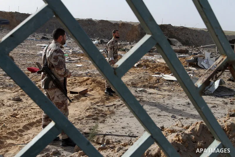 Palestinian security men look at a crater on the ground following an Israeli airstrike in the southern Gaza Strip near the town, of Rafah on May 27,2015. The Israeli air force carried out four strikes on militant targets...