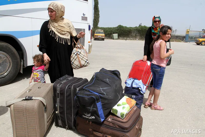 Palestinians stand next to their luggage upon their return to Gaza through the Rafah border crossing between Egypt and southern Gaza Strip May 27, 2015. Egyptian authorities opened the Rafah crossing on Tuesday and Wedne...