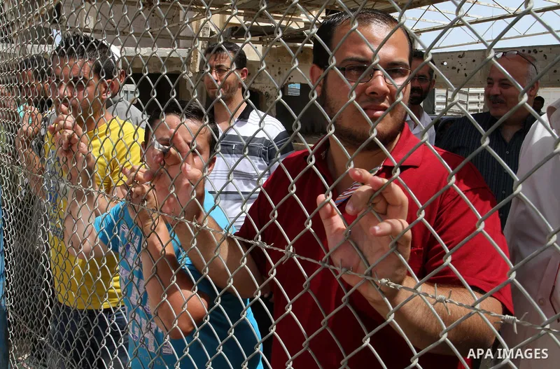 Palestinians stand behind fences as they wait their relatives coming from Egypt to the Gaza Strip through the Rafah border crossing between Egypt and the southern Gaza Strip May 27, 2015. Egyptian authorities opened the...