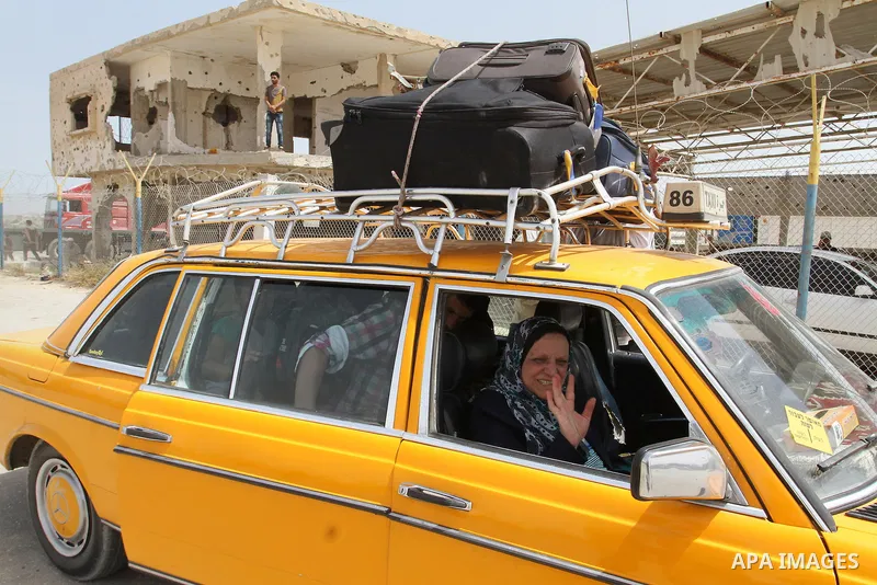 A Palestinian woman waves as she ride a car upon her return to Gaza through the Rafah border crossing between Egypt and southern Gaza Strip May 27, 2015. Egyptian authorities opened the Rafah crossing on Tuesday and Wedn...