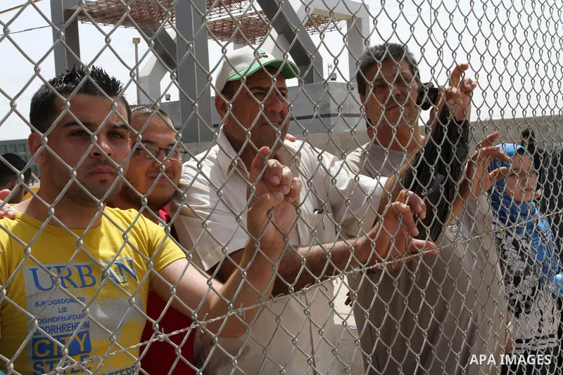 Palestinians stand behind fences as they wait their relatives coming from Egypt to the Gaza Strip through the Rafah border crossing between Egypt and the southern Gaza Strip May 27, 2015. Egyptian authorities opened the...