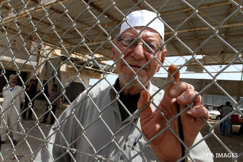 A Palestinian man stands behind a fence as he waits for his relatives to return at the Rafah border crossing between Egypt and southern Gaza Strip May 27, 2015. Egyptian authorities opened the Rafah crossing on Tuesday a...