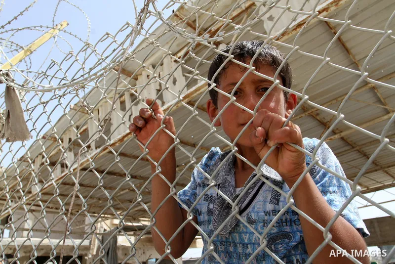 A Palestinian boy stands behind a fence as he waits for his relatives to return at the Rafah border crossing between Egypt and southern Gaza Strip May 27, 2015. Egyptian authorities opened the Rafah crossing on Tuesday a...