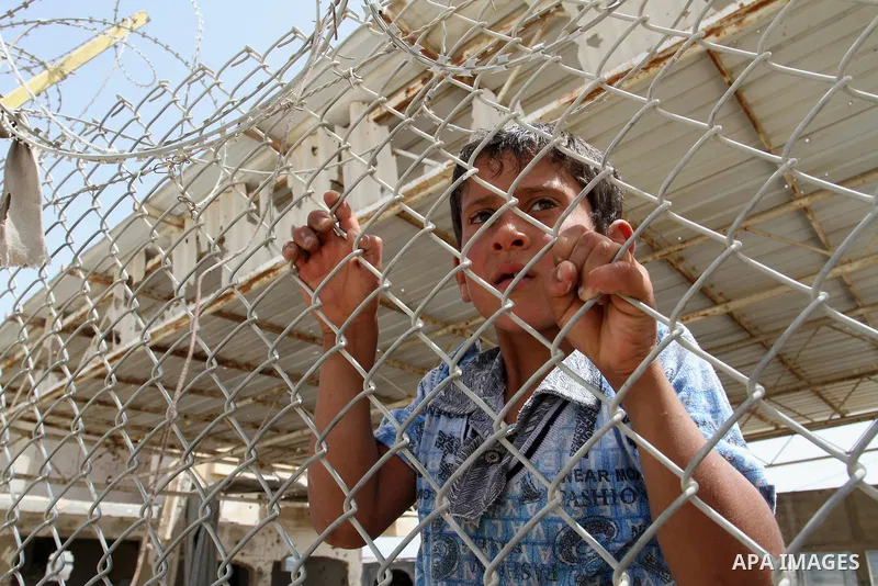 A Palestinian boy stands behind a fence as he waits for his relatives to return at the Rafah border crossing between Egypt and southern Gaza Strip May 27, 2015. Egyptian authorities opened the Rafah crossing on Tuesday a...