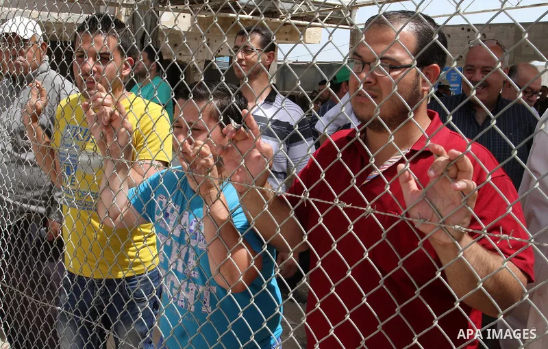 Palestinians stand behind fences as they wait their relatives coming from Egypt to the Gaza Strip through the Rafah border crossing between Egypt and the southern Gaza Strip May 27, 2015. Egyptian authorities opened the...