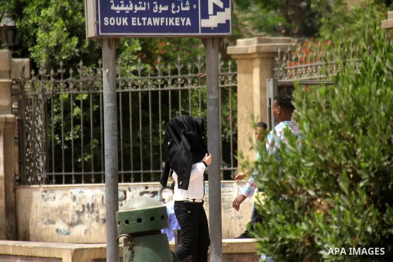 Egyptians walk in a street in downtown Cairo on May 27, 2015. Hot weather with sandstorm hit Egypt on Wednesday, and the temperature reached 44 degree Celsius (111 degree Fahrenheit) at noon in some regions of the countr...