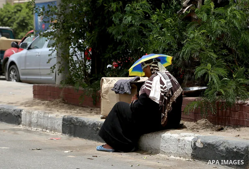 An Egyptian sits in a street in downtown Cairo on May 27, 2015. Hot weather with sandstorm hit Egypt on Wednesday, and the temperature reached 44 degree Celsius (111 degree Fahrenheit) at noon in some regions of the coun...