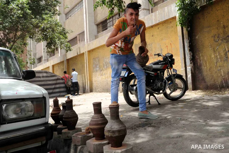 An Egyptian man washes himself with cold water in a street in downtown Cairo on May 27, 2015. Hot weather with sandstorm hit Egypt on Wednesday, and the temperature reached 44 degree Celsius (111 degree Fahrenheit) at no...