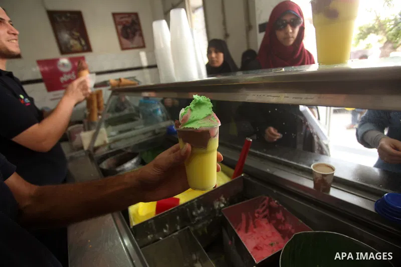 Palestinians buy ice-cream during hot weather in Gaza city on May 27, 2015. Hot weather hit Gaza Strip on Wednesday, and the temperature reached more than 39 degrees Celsius (102 degree Fahrenheit) at noon, Gazans escape...