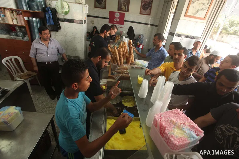 Palestinians buy ice-cream during hot weather in Gaza city on May 27, 2015. Hot weather hit Gaza Strip on Wednesday, and the temperature reached more than 39 degrees Celsius (102 degree Fahrenheit) at noon, Gazans escape...