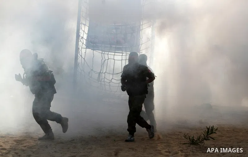 Masked Palestinian militants of the National Resistance Brigades, a group linked to the Democratic Front for the Liberation of Palestine, demonstrate their skills during a training exercise in Khan Younis in the southern...